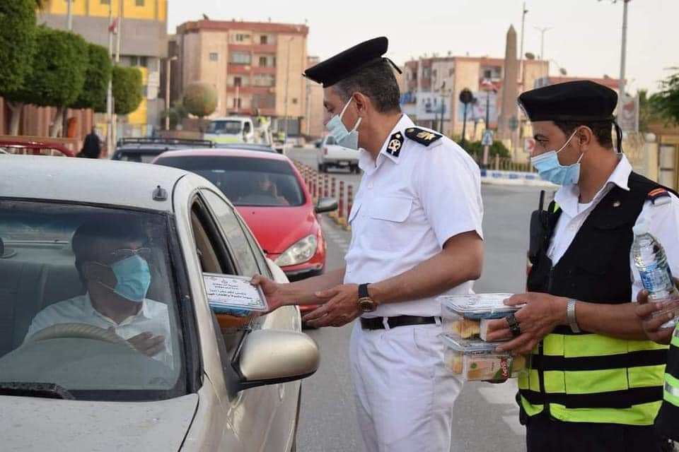 ضباط مديرية أمن سوهاج يقومون بتوزيع وجبات إفطار مجانية للصائمين من المارة وقائدي السيارات في المحافظة قبل Ezda65pXsAAqWIn